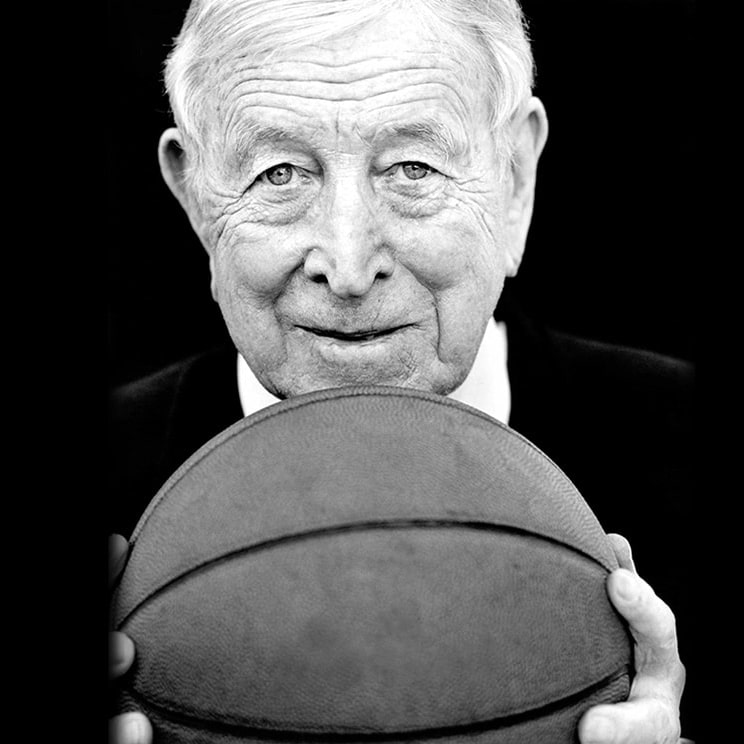 John Wooden con un balón de baloncesto