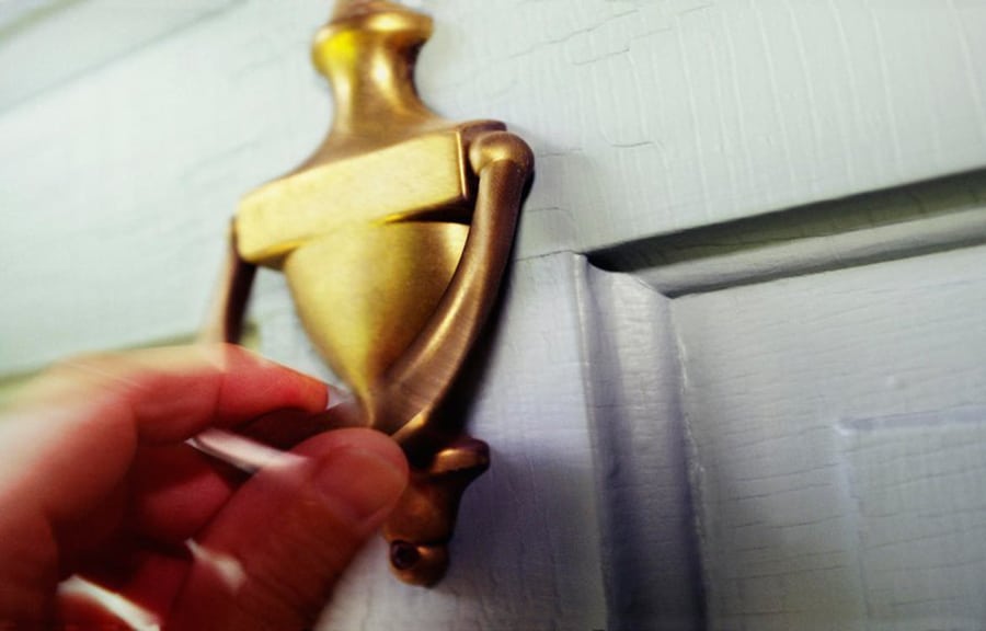 Hand knocking on a doorknob